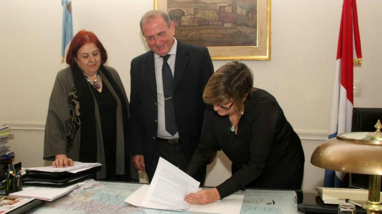 González y Schneider durante la firma del convenio.