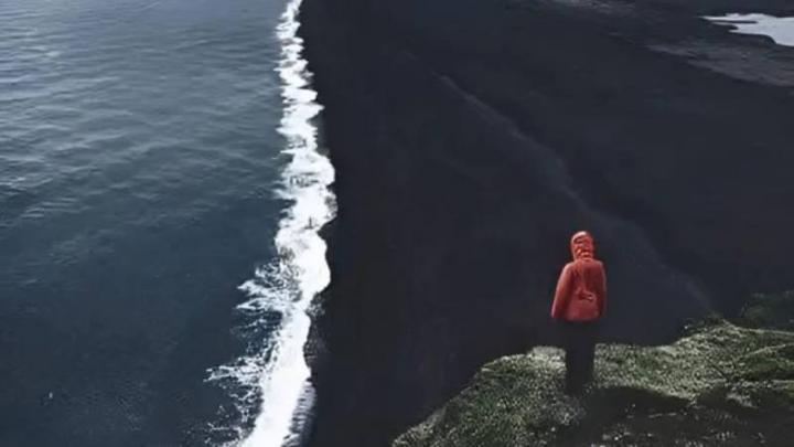 Una playa que no parece de este planeta: tiene arenas negras y auroras boreales