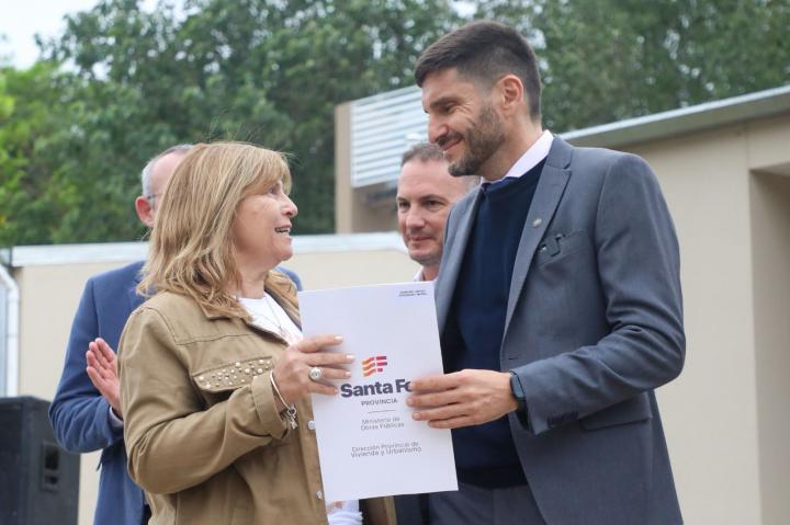 Una de las adjudicatarias recibe de manos de Pullaro la escritura de su vivienda.